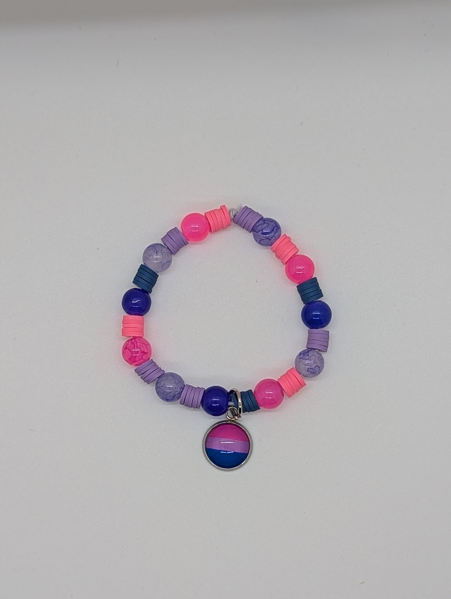 Colorful beaded bracelet with a bisexual pride charm on a white background