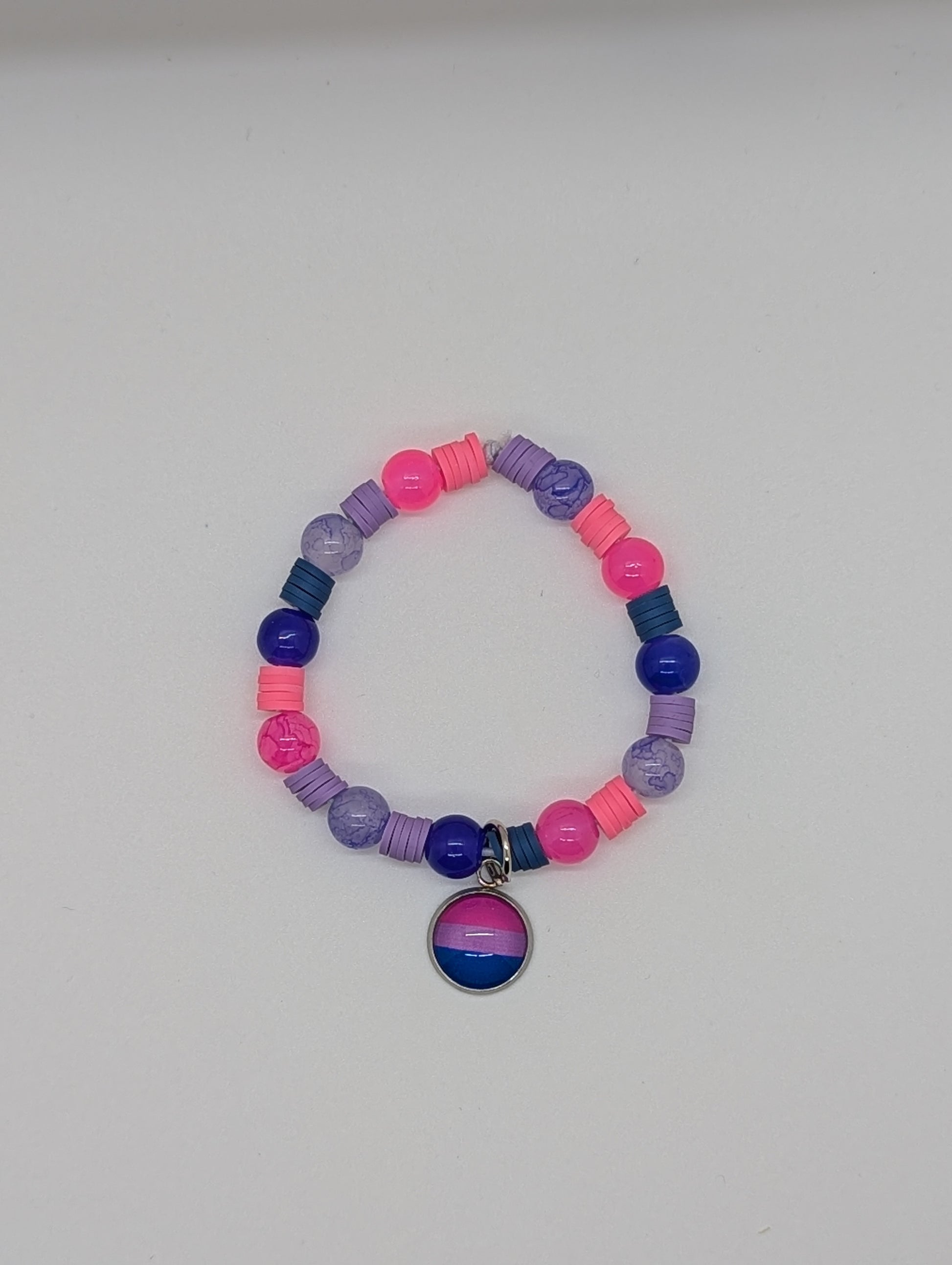Colorful beaded bracelet with a bisexual pride charm on a white background