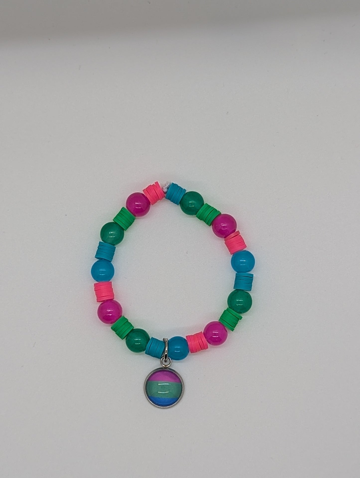 Colorful beaded bracelet with a circular charm on a white background