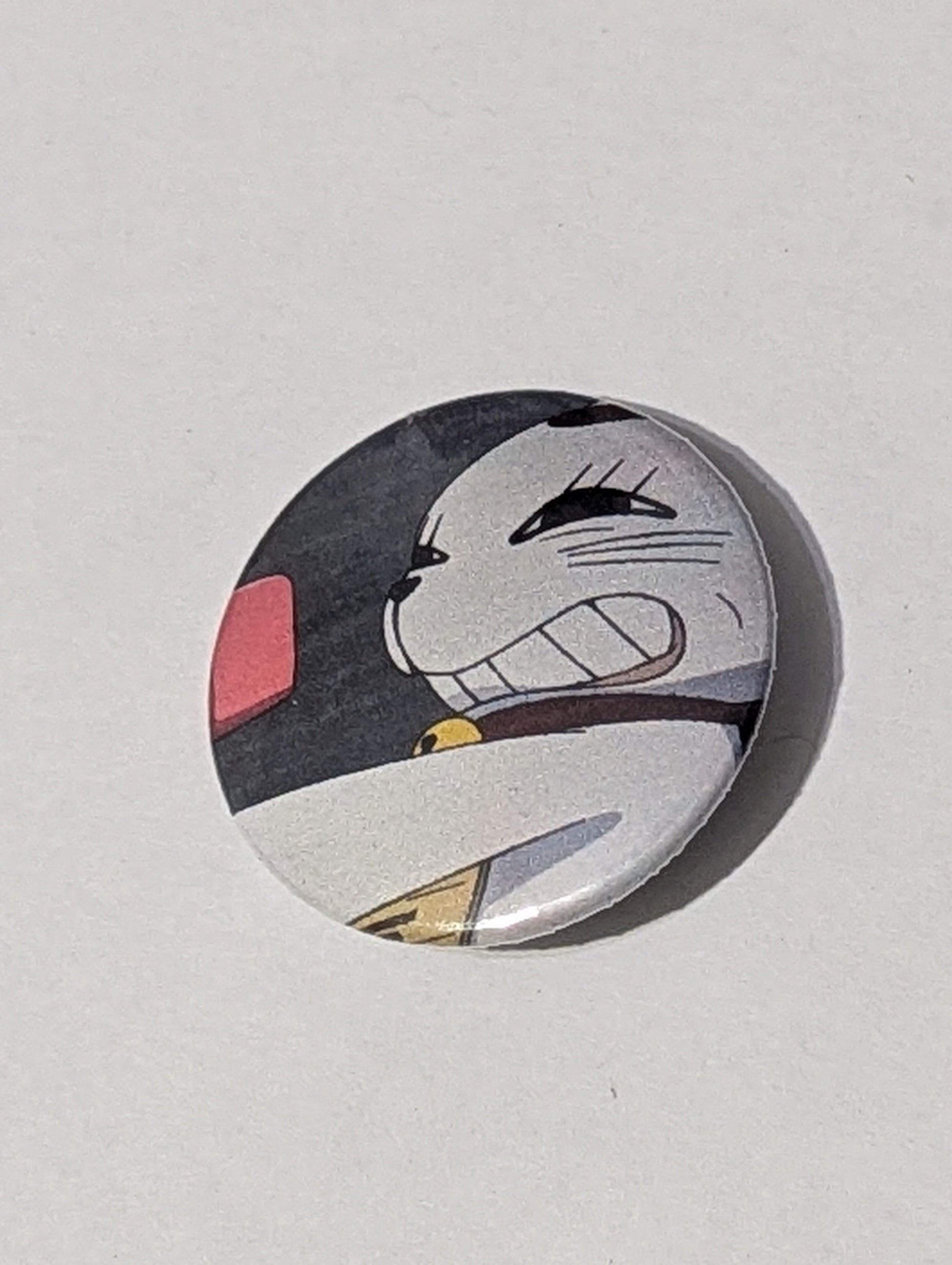Circular badge with a stylized cat face design on a light gray background