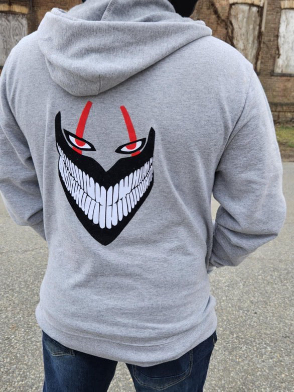 Gray hoodie with a graphic design on the back, worn by a person outdoors.
