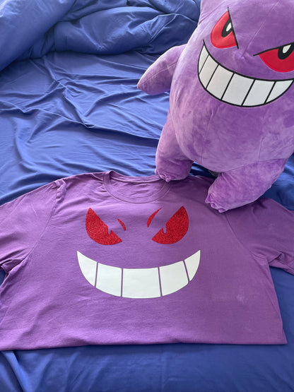 Gengar Face Tee with a Gengar stuffed doll next to it.