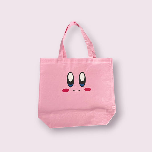 Soft pink tote bag with a kirby face.