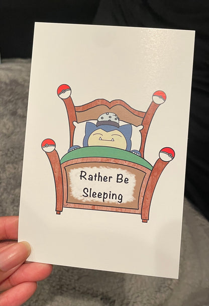 Card with a cartoon character sleeping in bed and 'Rather Be Sleeping' text.