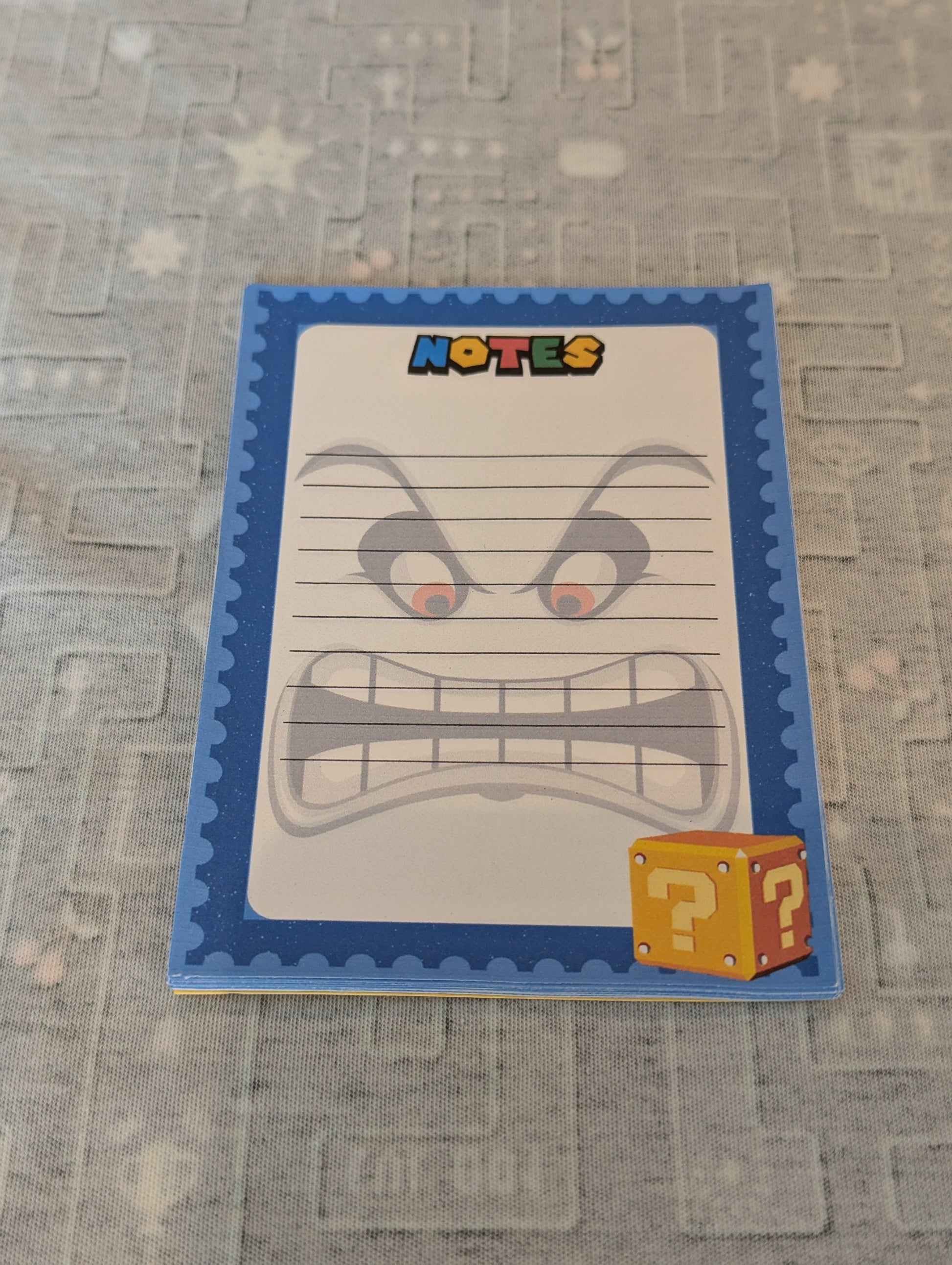 Notepad with an angry face design on a textured surface