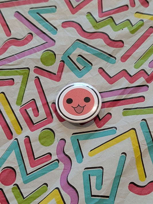 Round object with a smiley face design on a colorful geometric patterned background