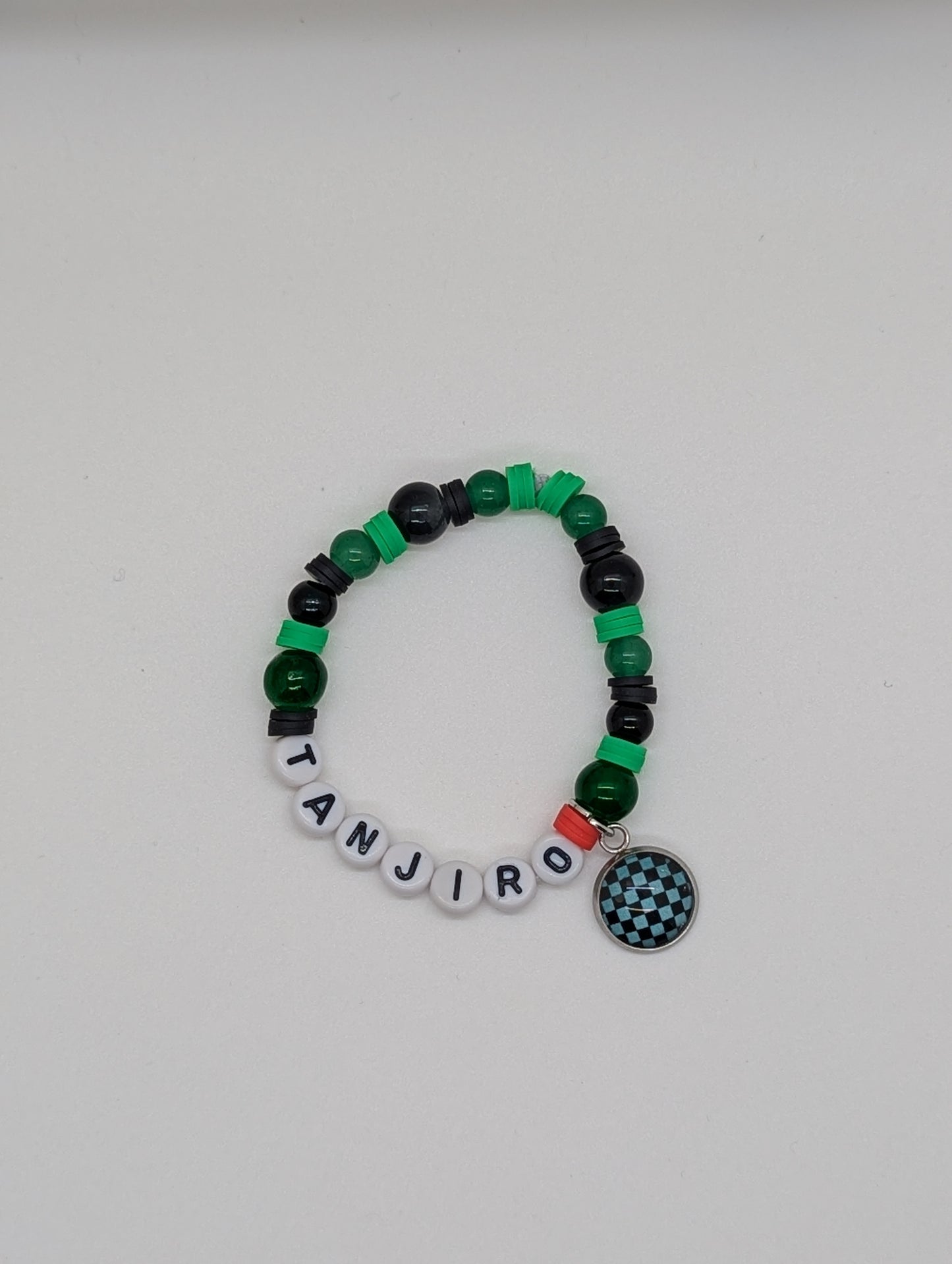 Demon Slayer Bracelet with Tanjiro name beads and a charm on a white background